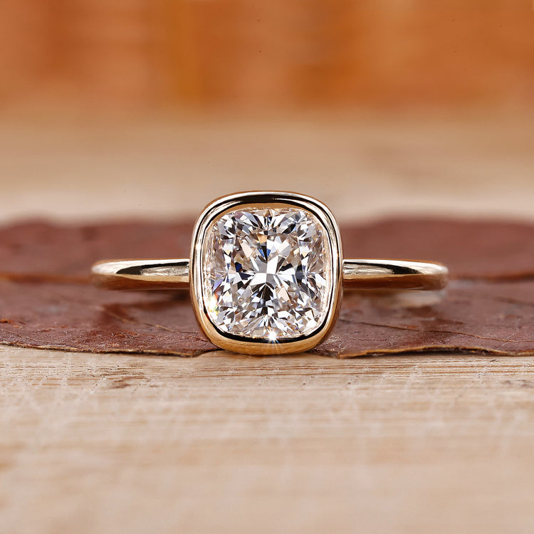 Cushion cut engagement ring with bezel set ring.