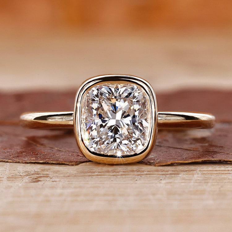Cushion cut engagement ring with bezel set ring.