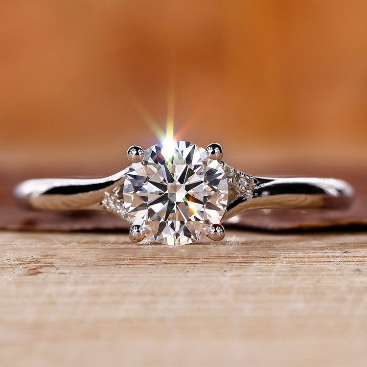 Round brilliant cut diamond ring with a split shank design.