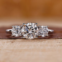 Three stone engagement ring crafted in a white gold trellis ring setting.