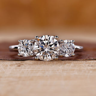 Three stone engagement ring crafted in a white gold trellis ring setting.