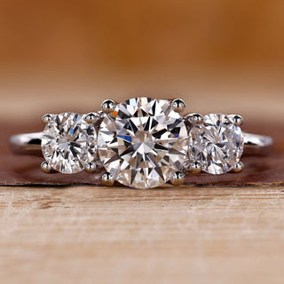 Three stone engagement ring crafted in a white gold trellis ring setting.