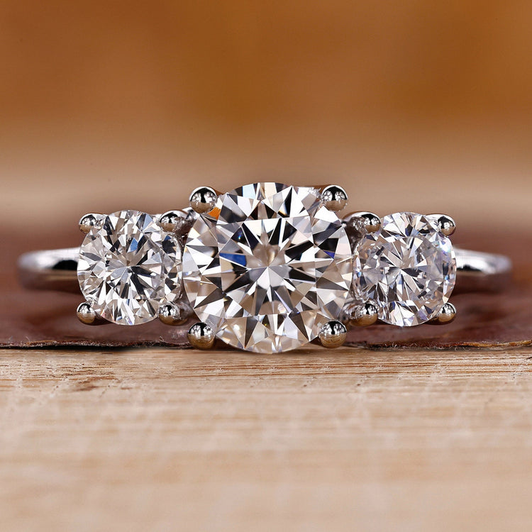 Three stone engagement ring crafted in a white gold trellis ring setting.