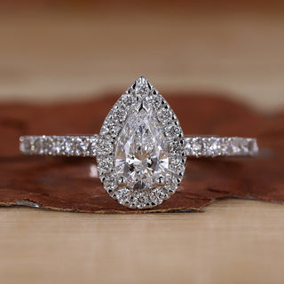 Pear halo engagement ring with round cut pave band.