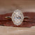 Close-up of a sparkling oval halo engagement ring with a polished silver band Close-up of a sparkling oval halo engagement ring with a polished silver band
