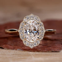 Close-up of a sparkling oval halo engagement ring with a polished silver band