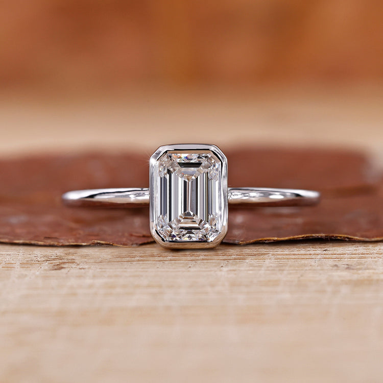 Bezel set engagement ring with emerald cut diamond ring.