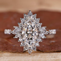 White gold engagement ring with marquise diamond and round halo.