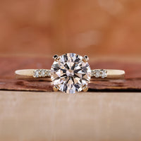 round engagement ring with yellow gold ring band.