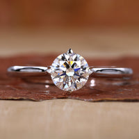 Close-up of round solitaire diamond ring with compass prongs setting