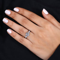 Pear side stone engagement ring featuring a central diamond and tapered side stones.