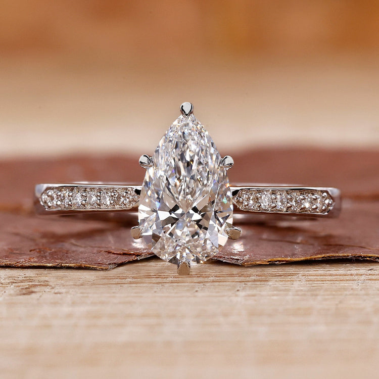 pear cut engagement ring with tapered pave band.