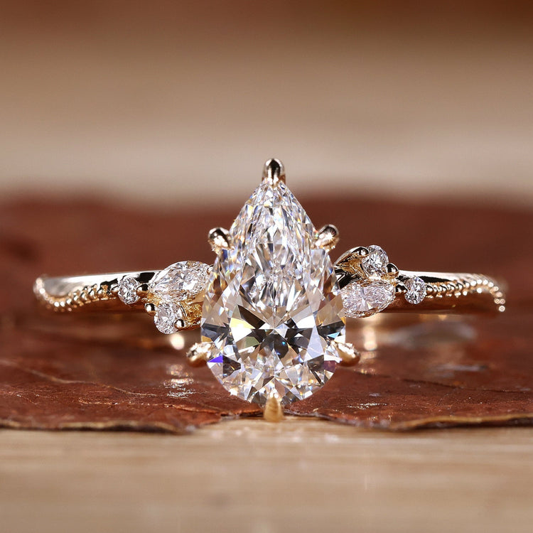 Close-up of a pear cut diamond ring with round and marquise side stones