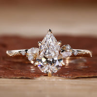 Close-up of a pear cut diamond ring with round and marquise side stones