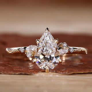 Close-up of a pear cut diamond ring with round and marquise side stones