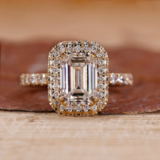 Emerald cut engagement ring with two side halo ring.