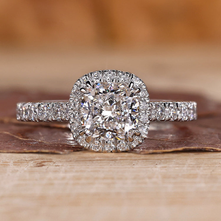 Cushion cut halo engagement ring with round diamond halo in yellow gold.