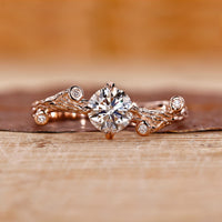 Rose gold engagement ring with round cut diamond and four claw prong setting.