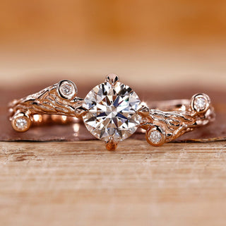 Rose gold engagement ring with round cut diamond and four claw prong setting.