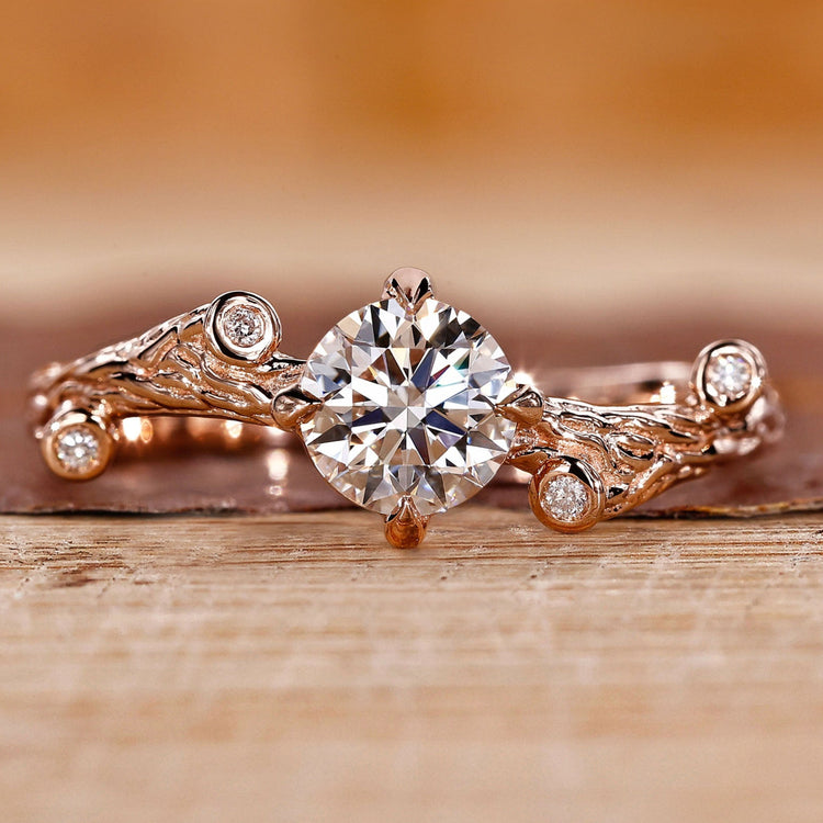 Rose gold engagement ring with round cut diamond and four claw prong setting.