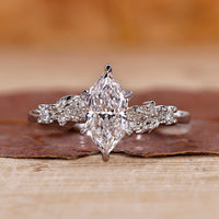 White gold engagement ring with Dutch marquise diamond and round side stones.