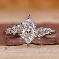 White gold engagement ring with Dutch marquise diamond and round side stones.