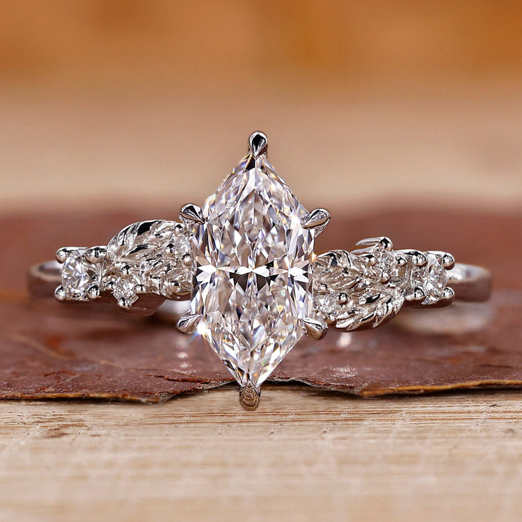 White gold engagement ring with Dutch marquise diamond and round side stones.