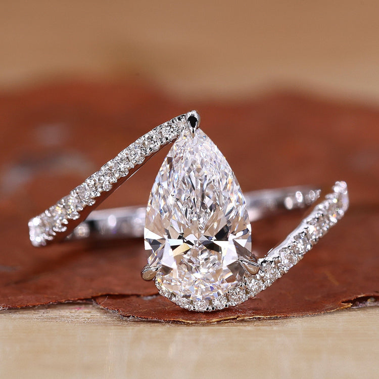 Pear shaped engagement ring with white gold engagement ring.