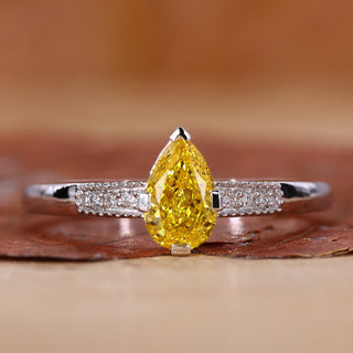 Yellow diamond pear engagement ring with pave diamond band.