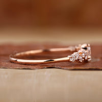 Round side stones add detail to this elegant rose gold ring.