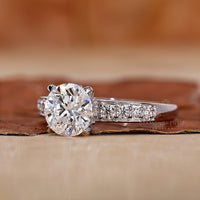 Round cut diamond ring set in tapered shank pave ring.