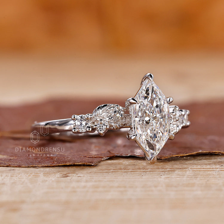 Claw prong setting ring with Dutch marquise diamond and custom side stones.