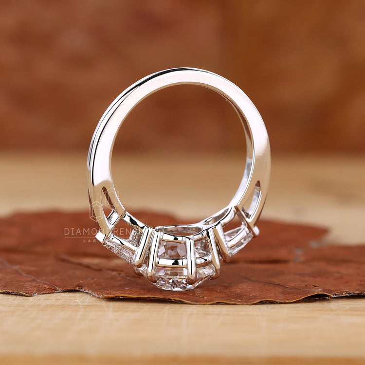 Custom ring with pear shaped side stones and central diamond in claw setting.