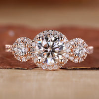 3 stone engagement ring with round cut diamonds in rose gold.