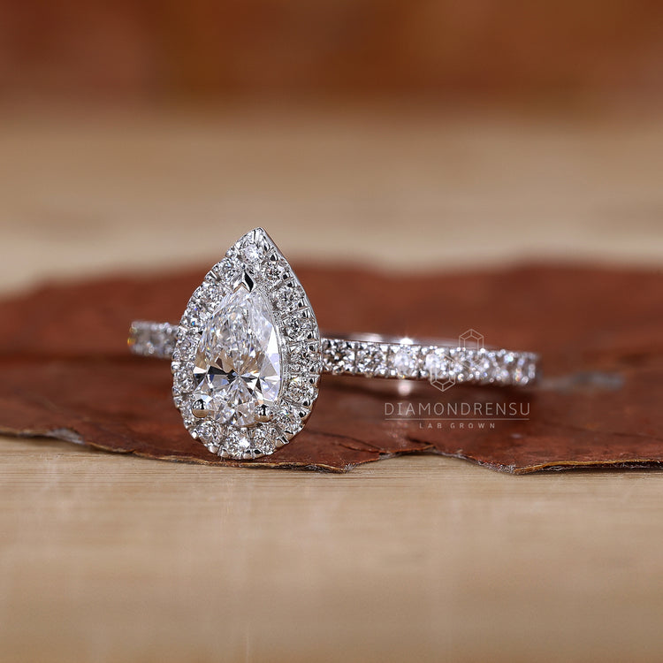 White gold engagement ring featuring a pear shaped halo.
