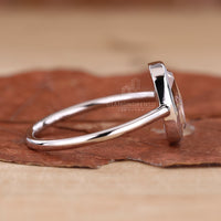 A bezel set diamond ring with a cushion rose cut diamond, shining beautifully in natural light.