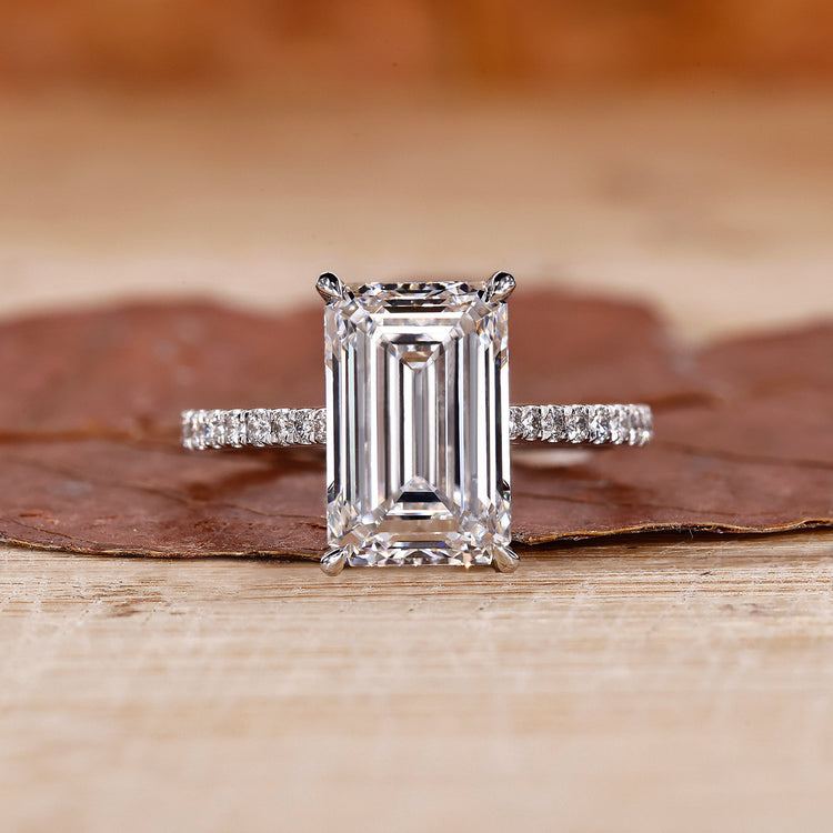 gold emerald cut engagement ring with pave band.