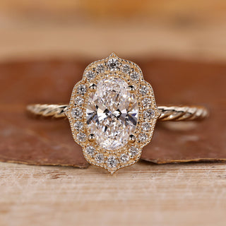 Oval gold engagement ring with halo setting ring.