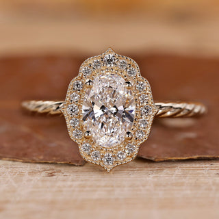 Oval gold engagement ring with halo setting ring.