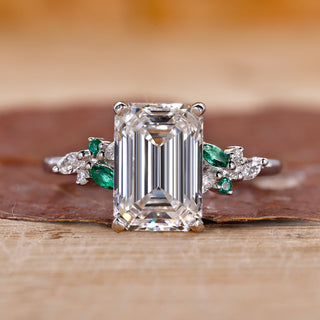 Emerald cut diamond engagement ring with round and marquise side stones.