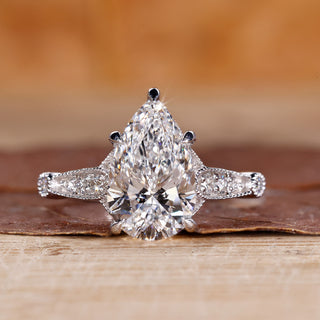 Vintage diamond ring with pear cut diamond and round side stones.