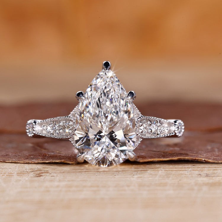 Vintage diamond ring with pear cut diamond and round side stones.