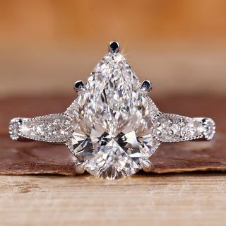 Vintage diamond ring with pear cut diamond and round side stones.