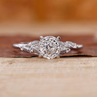 Portuguese cut diamond ring with round side stones in white gold.
