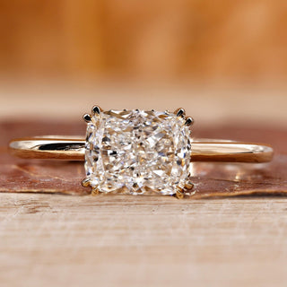 Elongated cushion cut diamond ring with double claw prong in yellow gold.