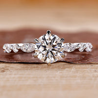 Round cut diamond ring set in a classic white gold band with elegant detail.