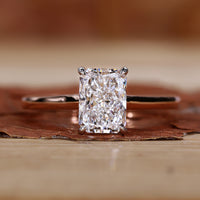 Radiant cut diamond ring in a sleek four prong claw setting.