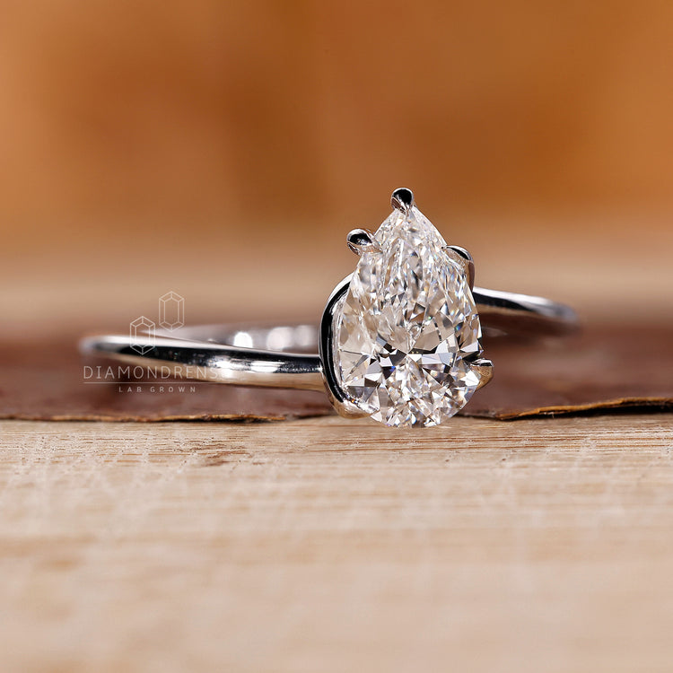 Solitaire diamond ring featuring pear cut diamond in a twisted white gold design.