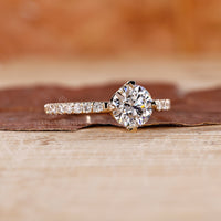 Round cut diamond ring with compass prong setting.