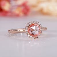 Rose gold ring with pink diamond and halo setting.